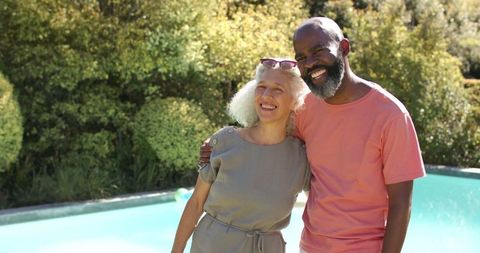 Senior Friends Smiling by Pool on Sunny Day