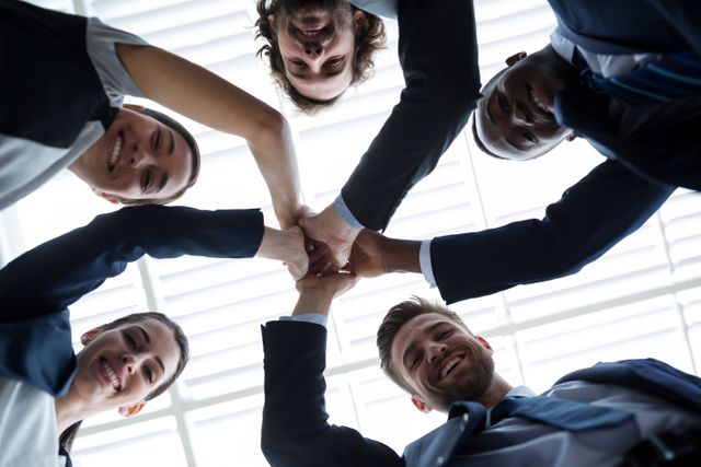 Diverse group of business professionals giving high five, symbolizing teamwork and success. Ideal for use in corporate presentations, team-building materials, motivational posters, and business websites to highlight collaboration and unity.