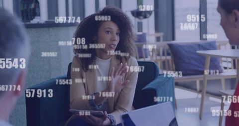 Businesswoman presenting data on tablet in modern lounge with floating analytics overlay
