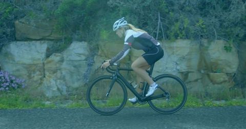 Female cyclist riding on scenic mountain path