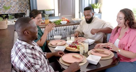 Joyful friends sharing meal at home