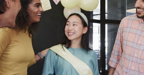 Colleagues celebrate office baby shower with joyful interaction