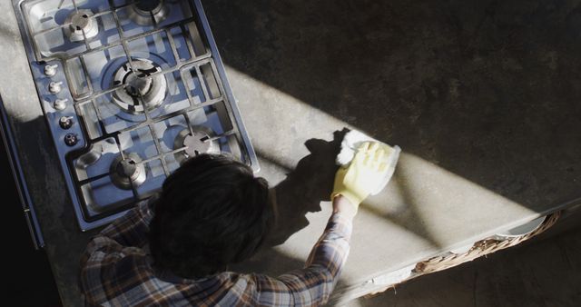 Person Cleaning Kitchen Counter Beside Gas Stove Under Sunlight - Download Free Stock Images Pikwizard.com