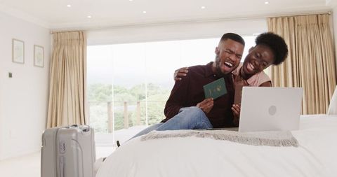 Enthusiastic couple planning travel adventures from bedroom