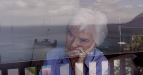 Elderly Woman Looking Through Window in Thoughtful Reflection