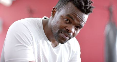 Fit African American Man Resting in Gym Exhibiting Determined Focus