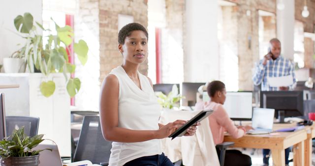 Confident Businesswoman Holding Tablet in Modern Open Office - Download Free Stock Images Pikwizard.com