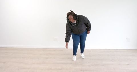 Woman Stretching on Wooden Floor in Casual Wear