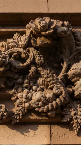 Tilting vertical video revealing ornate stone relief with carved grape vines and baroque ornament