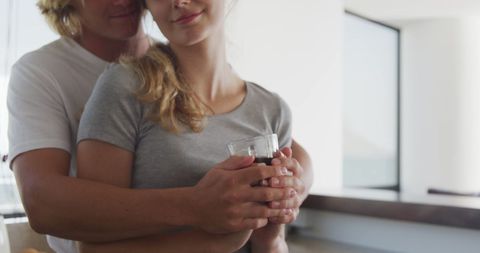 Couple Embracing in Kitchen with Morning Coffee