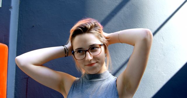 Confident Young Woman with Glasses Touching Hair - Download Free Stock Images Pikwizard.com