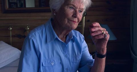 Thoughtful Senior Woman Sitting on Bed Reflecting at Home