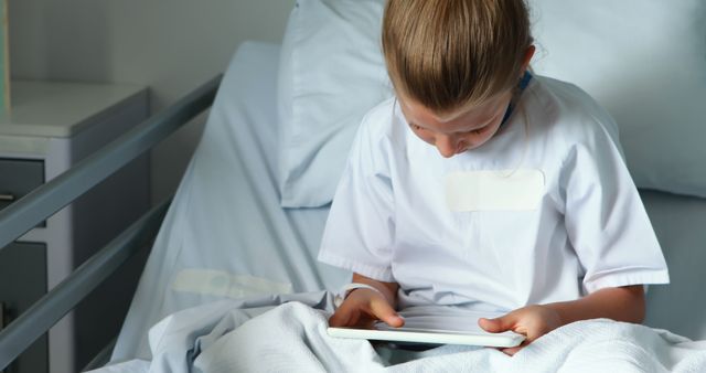 Child in hospital bed playing with digital tablet - Download Free Stock Images Pikwizard.com