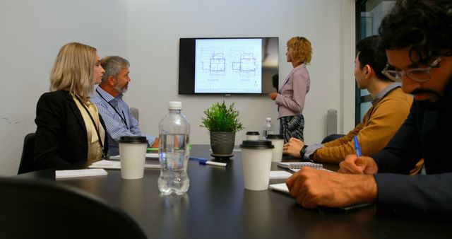 Team Collaborating on Architectural Blueprint Presentation in Modern Office - Download Free Stock Images Pikwizard.com