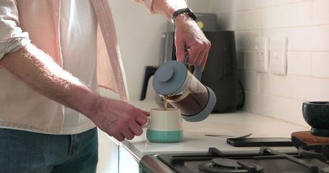 Man Pouring French Press Coffee in Home Kitchen