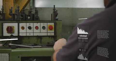 Technician reaching for red emergency stop on green industrial machine control panel