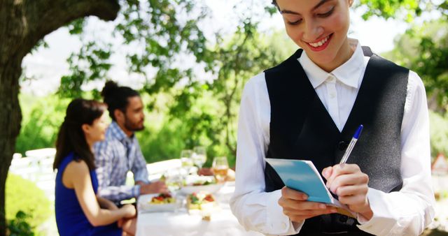 Smiling waitress serving couple dining outdoors at restaurant patio - Download Free Stock Images Pikwizard.com