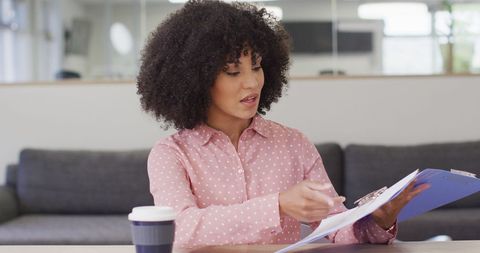 Businesswoman Engaging in Video Call with Documents in Office