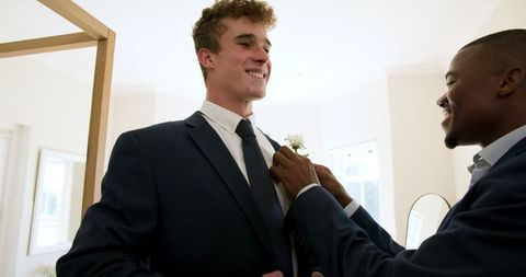 Groom and best man sharing joyful moment before wedding ceremony