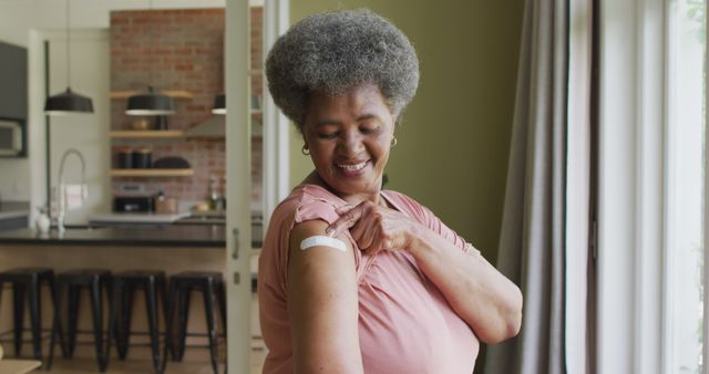 Senior Woman Proudly Displays Vaccination Bandage in Living Room - Download Free Stock Images Pikwizard.com