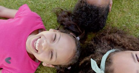 Joyful Kids Lying on Grass at School Playground