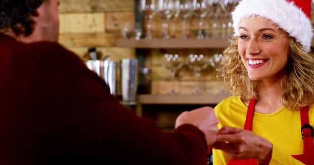 Happy Female Barista in Santa Hat Taking Payment from Customer - Download Free Stock Images Pikwizard.com