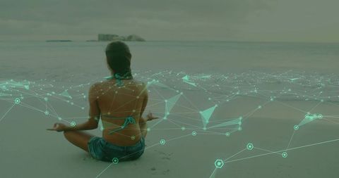 Meditating woman on beach practicing mindfulness with teal digital network overlay