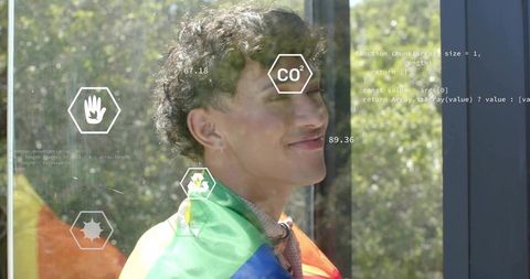 Young man wearing rainbow pride flag with augmented reality overlays and data visuals