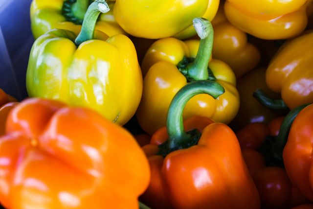 Bell peppers in vibrant yellow and orange colors. Perfect for food blogs, cooking websites, or nutrition guides emphasizing fresh produce and healthy eating. Great for advertising organic food stores or vegetarian recipes.