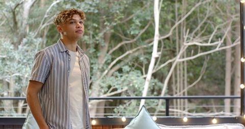 Young Man Relaxing on Outdoor Deck with Scenic Forest View