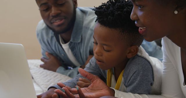 African American family watching something on laptop together - Download Free Stock Images Pikwizard.com