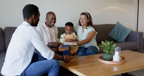 Family bonding time at home reading together on cozy couch