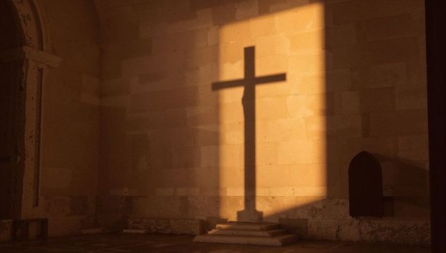 Cruciform shadow on historic chapel's dimly lit wall
