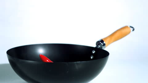 Red Chili Dropping Into Wok in Slow Motion for Cooking Concept
