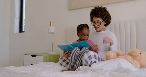 Caregiver Reading Story to Child on Cozy Bedroom Bed
