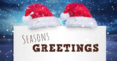 Season's greetings with santa hats in snowy winter scene