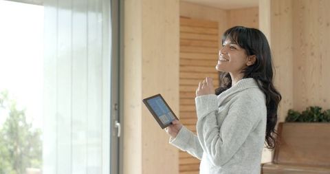Professional Hispanic Woman Holding Data Tablet in Bright Home Office