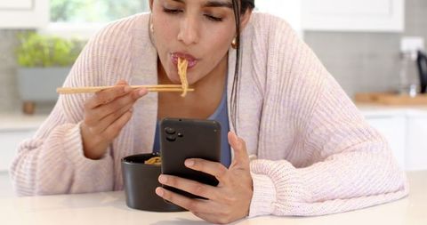 Woman Enjoying Meal with Technology in Modern Kitchen