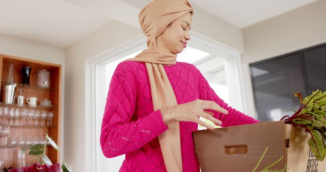 Smiling Woman in Hijab Unpacking Fresh Groceries in Modern Kitchen - Download Free Stock Images Pikwizard.com