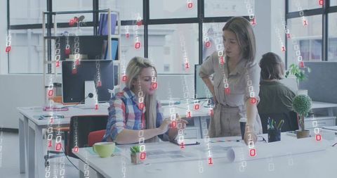 Women collaborating on color swatches in modern coworking office with binary data overlay