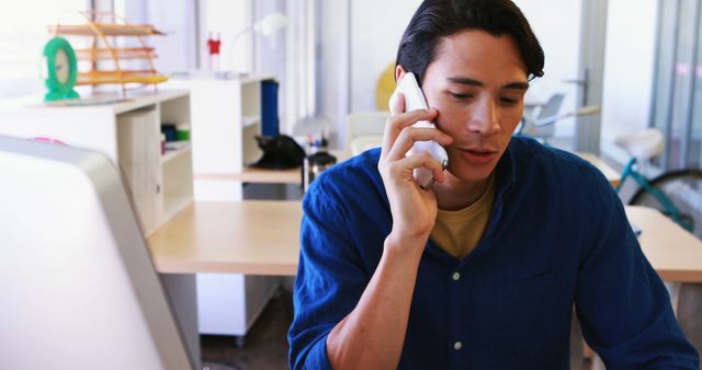 Young Man on Phone in Modern Office Setting - Download Free Stock Images Pikwizard.com