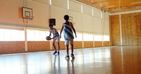Boys Practicing Basketball Skills in Gymnasium