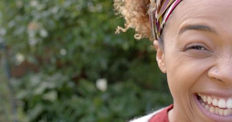 Joyful African American Woman in Lush Garden with Focus on Smile