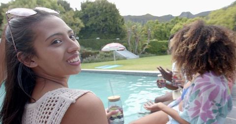 Young Friends Socializing Poolside With Refreshing Drinks