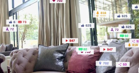 Tufted velvet sofa with metallic silver and burgundy pillows in bright modern living room