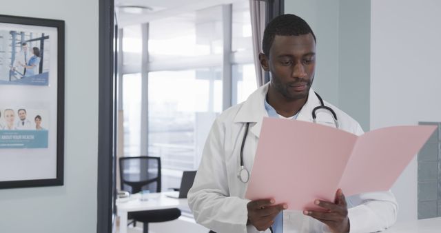 Confident Doctor Reviewing Patient Folder in Modern Clinic - Download Free Stock Images Pikwizard.com