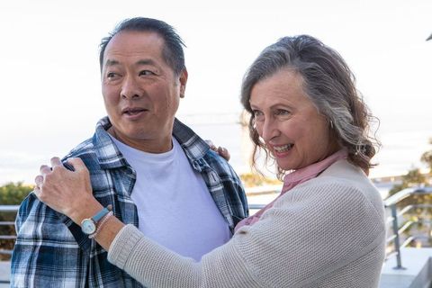 Senior couple embracing by seaside on sunny day