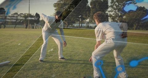 Two cricketers fielding on sunlit park ground with tactical grid overlay and focus