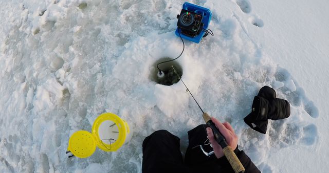 Ice fisherman fishing in snowy region during winter