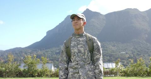 Asian soldier walking through mountains in camouflage gear